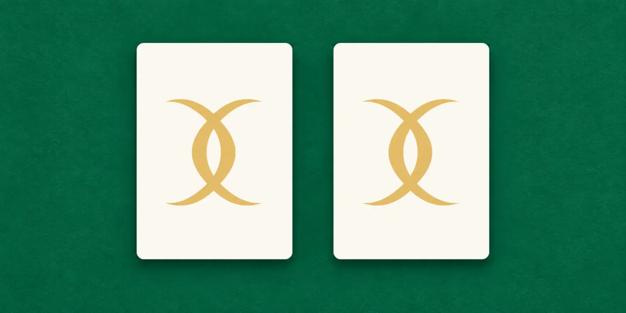 Due carte identiche affiancate su un tavolo verde, ciascuna con lo stesso motivo dorato